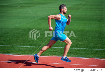 Athletic mature man running on stadium, speed 95604764