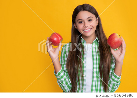 happy child with apple fruit on yellow background 95604996