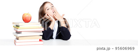 Tired little child girl sleeping on the desk at school. 95606969