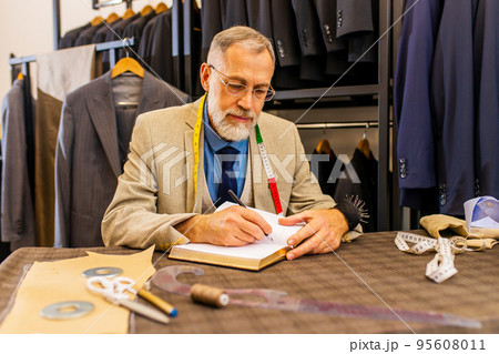 well-dressed bearded mature handsome man working in his atelier studio 95608011