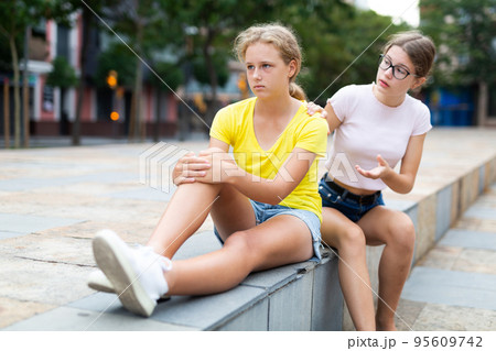 Two young girls having quarrel outdoors 95609742