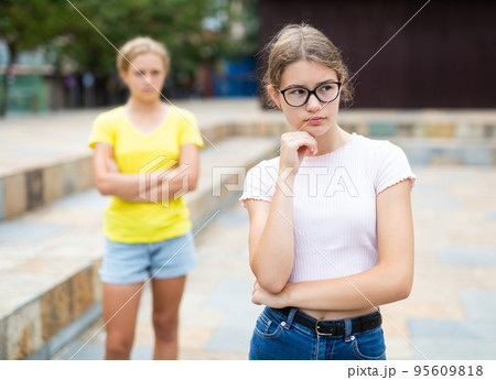 Youth girls quarreling between each other outdoors Youth girls quarreling between each other outdoors 95609818