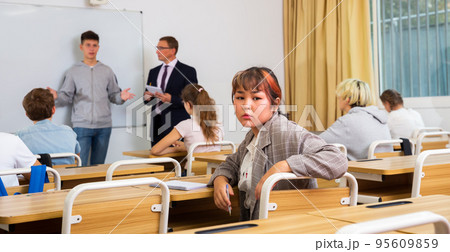 Teenage girl sitting at desk in classroom Teenage girl sitting at desk in classroom 95609859