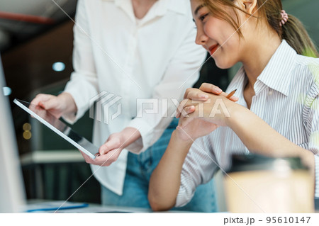 Negotiation, Analysis, Discussion, Portrait of an Asian woman economist and marketer using tablet computer to plan investments and financial to prevent risks and losses for the company. 95610147
