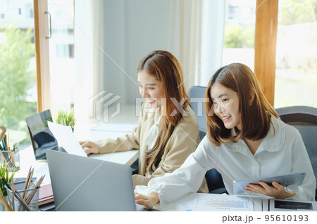 Negotiation, Analysis, Discussion, Portrait of an Asian woman economist and marketer using computer laptop to plan investments and financial to prevent risks and losses for the company. 95610193