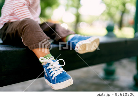 Little baby feet in blue sneakers. Close-up. High quality photo 95610506