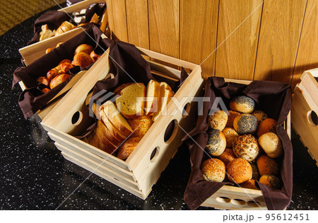 A buffet table with variety of bread in the wooden baskets A buffet table with variety of bread in the wooden baskets 95612451