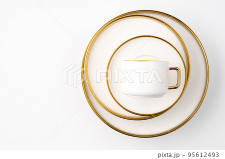 A set of white and brown ceramic plate and cup on a white background. Top view 95612493
