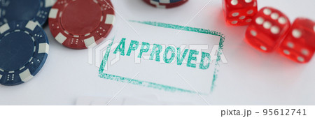 Stamp approved standing near playing cards and chips in casino with dice Stamp approved standing near playing cards and chips in casino with dice 95612741