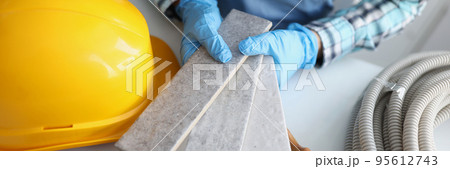 Builder hold grey tiles samples for bathroom in workshop, foreman choose perfect shade Builder hold grey tiles samples for bathroom in workshop, foreman choose perfect shade 95612743