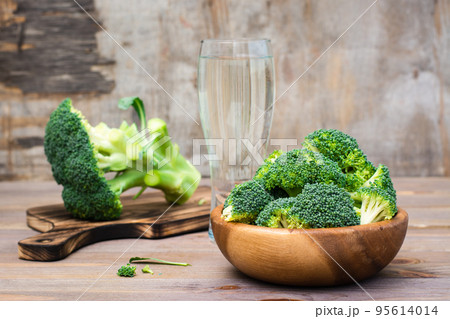 Ready to eat fresh raw broccoli is divided into inflorescences in a wooden plate and on a cutting board on a wooden table. Healthy lifestyle, nutrition and zero waste concept Ready to eat fresh raw broccoli is divided into inflorescences in a wooden plate and on a cutting board on a wooden table. Healthy lifestyle, nutrition and zero waste concept 95614014