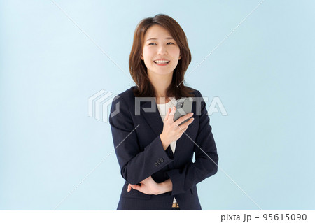スマホを持つ女性 青背景 スマホを持つ女性 青背景 95615090