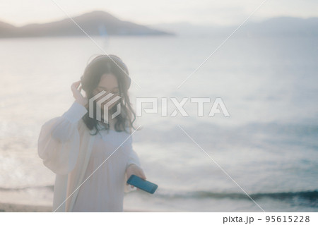 海辺で音楽を聴く女性の写真 海辺で音楽を聴く女性の写真 95615228