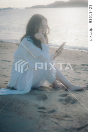 海辺で電話をかける女性の写真 海辺で電話をかける女性の写真 95615425