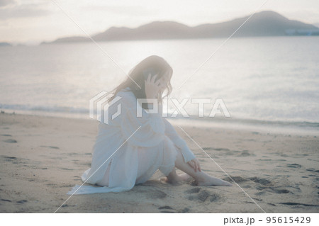 海辺で電話をかける女性の写真 海辺で電話をかける女性の写真 95615429