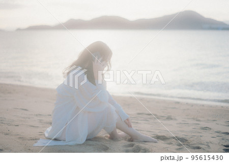 海辺で電話をかける女性の写真 95615430