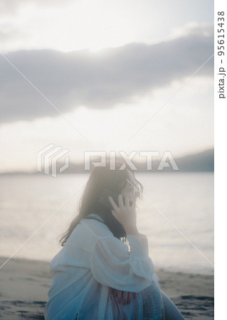 海辺で電話をかける女性の写真 海辺で電話をかける女性の写真 95615438