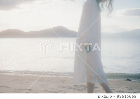 海辺で音楽を聴く女性の写真 95615668