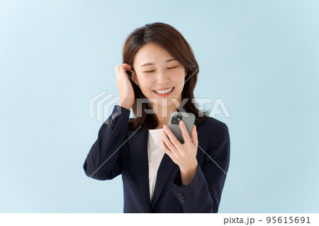 スマホを持つ女性　青背景 95615691