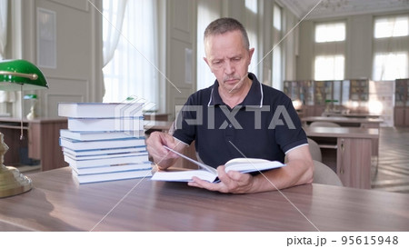 Portrait of caucasian Senior man working with book in public library. 95615948