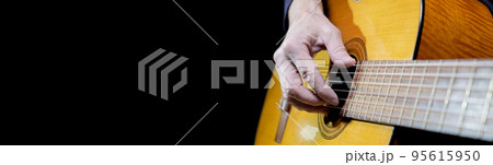 Guitarist playing acoustic guitar on black background, selective focus. Guitarist playing acoustic guitar on black background, selective focus. 95615950