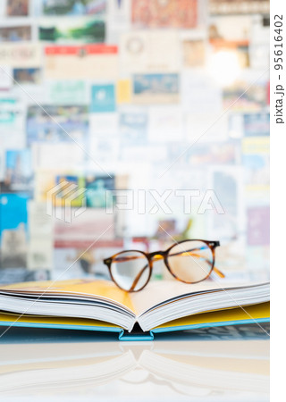 Open book with soft blurred reading glasses in background Open book with soft blurred reading glasses in background 95616402