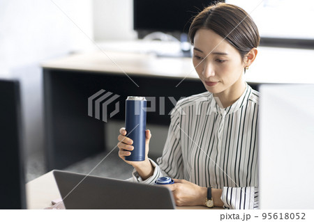オフィスでマイボトルを使う女性 95618052