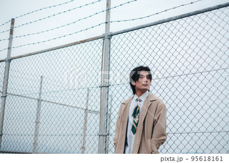 フェンスの前に立つ男性 95618161