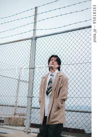 フェンスの前に立つ男性 95618163