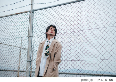 フェンスの前に立つ男性 95618166
