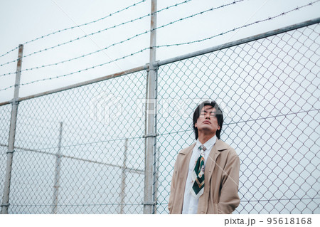 フェンスの前に立つ男性 95618168