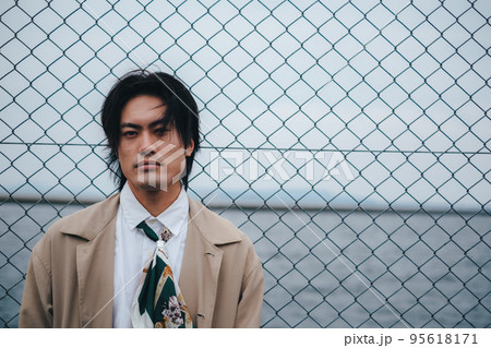 フェンスの前に立つ男性 95618171