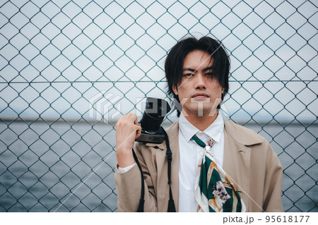 フェンスの前に立つ男性 95618177
