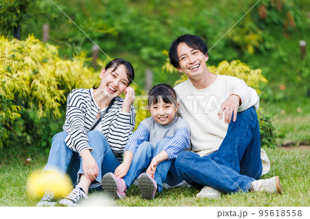 公園の芝生に座る仲良し家族 公園の芝生に座る仲良し家族 95618558