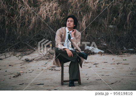 椅子に座ってポージングする男性 95619810