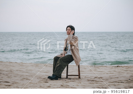 椅子に座ってポージングする男性 95619817