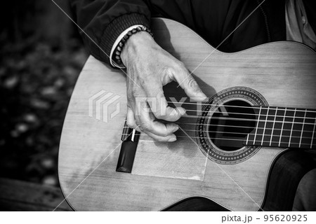 Closeup of musician playing guitar in the street Closeup of musician playing guitar in the street 95620925