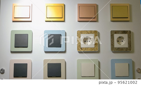 Various colored swithches and sockets on the wall. Electricity power for home. Various colored swithches and sockets on the wall. Electricity power for home. 95621002