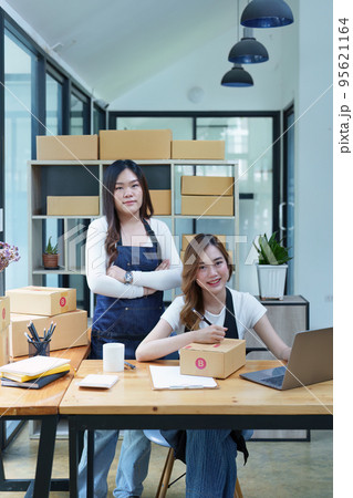 Starting small business entrepreneur of independent Asian woman smiling using computer laptop with cheerful success of online marketing package box items and SME delivery concept. 95621164