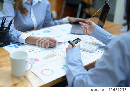 Financial analysts analyzing business reports on planned investment projects during corporate meeting discussions showcase successful teamwork with marketing plan, computers and calculators to work. Financial analysts analyzing business reports on planned investment projects during corporate meeting discussions showcase successful teamwork with marketing plan, computers and calculators to work. 95621253