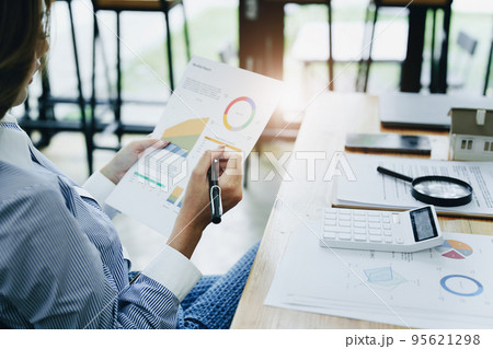 Portrait of a thoughtful Asian businesswoman looking at financial statements and making marketing plans using a computer on her desk. Portrait of a thoughtful Asian businesswoman looking at financial statements and making marketing plans using a computer on her desk. 95621298