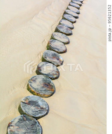 A wooden mall made of logs to protect the sandy beach on the sea. Summer vacation. A wooden mall made of logs to protect the sandy beach on the sea. Summer vacation. 95621352