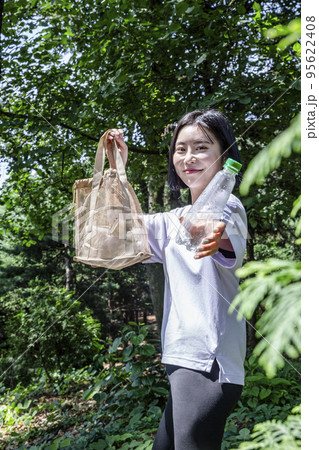 korean young woman hiking and plogging__picking up litter, garbage 95622408