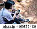 korean young women hiking and plogging_sitting down watching smartphone 95622489