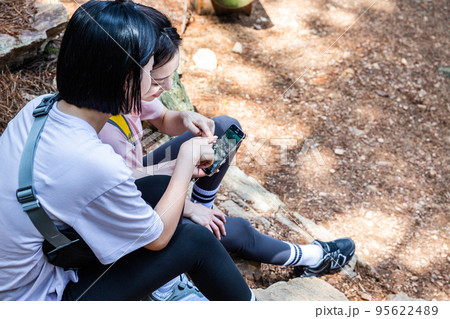 korean young women hiking and plogging_sitting down watching smartphone korean young women hiking and plogging_sitting down watching smartphone 95622489