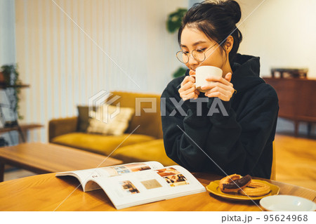 夜に部屋でコーヒーを飲む女性 95624968