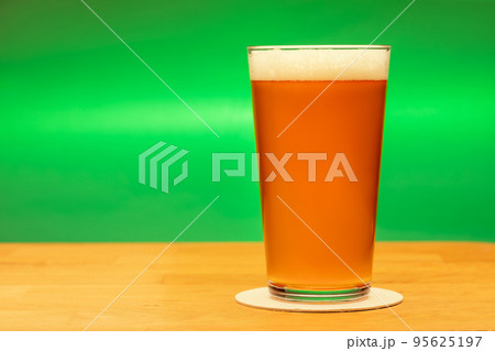 Full shaker pint glass of ale or beer on a table Full shaker pint glass of ale or beer on a table 95625197