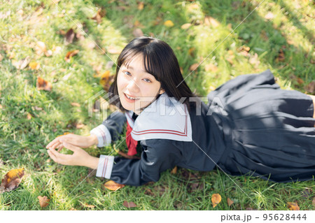 芝生で寝そべる女子高生 芝生で寝そべる女子高生 95628444