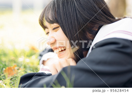 芝生で寝そべる女子高生 95628454