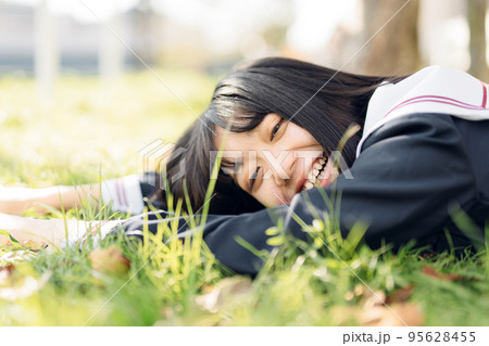 芝生で寝そべる女子高生 95628455